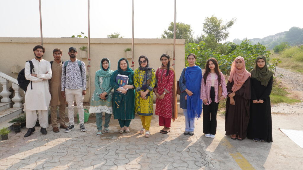 A group of university students gathered around a freshly planted tree, promoting teamwork and sustainability.